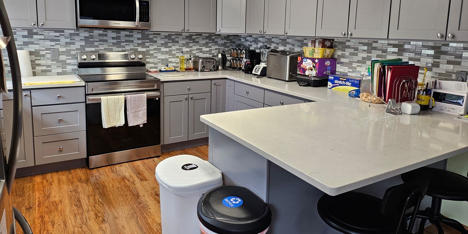 Two older women sit together on a couch, one lying back with a blanket while the other leans in, smiling and resting her hand on the other's shoulder, reflecting the warmth of holistic senior care in Snohomish County.